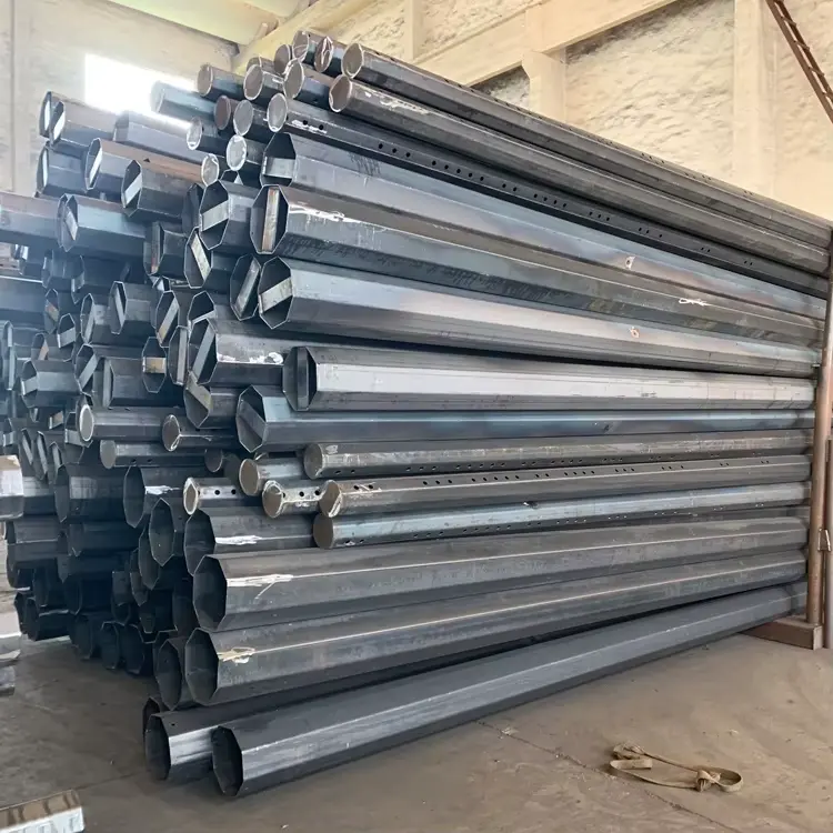 Lote de postes de acero octogonales fabricados por ORBE - Postes Metalicos, apilados en la planta de producción antes de pasar al proceso de galvanizado.